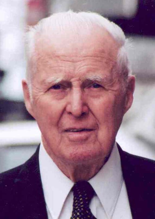 Norman Borlaug standing in a field of his semi-dwarf wheat.