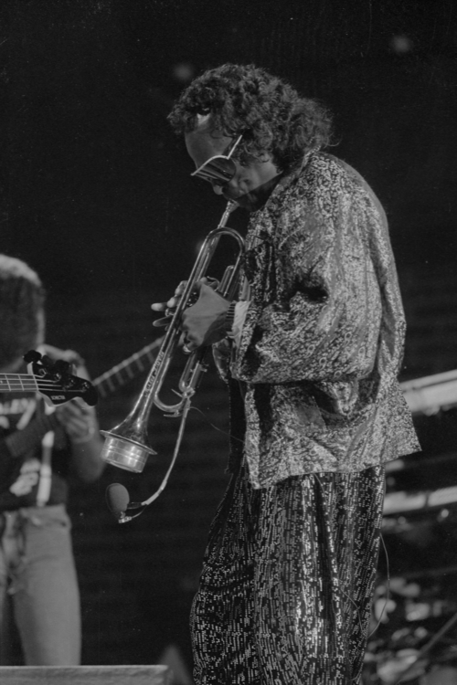 Photograph of Miles Davis playing trumpet on stage
