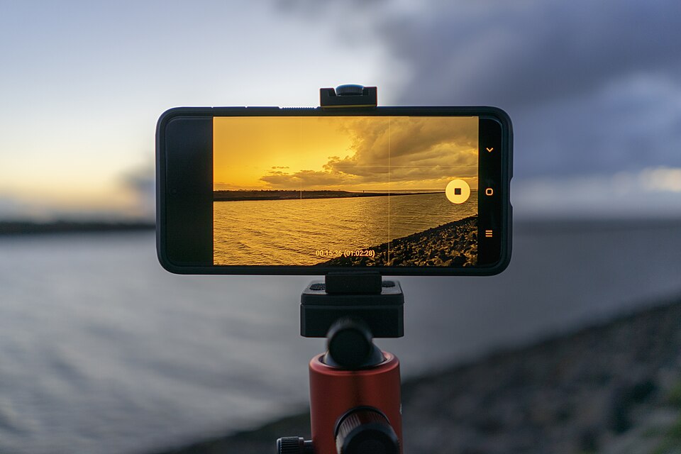 A person taking a photograph with a smartphone camera.