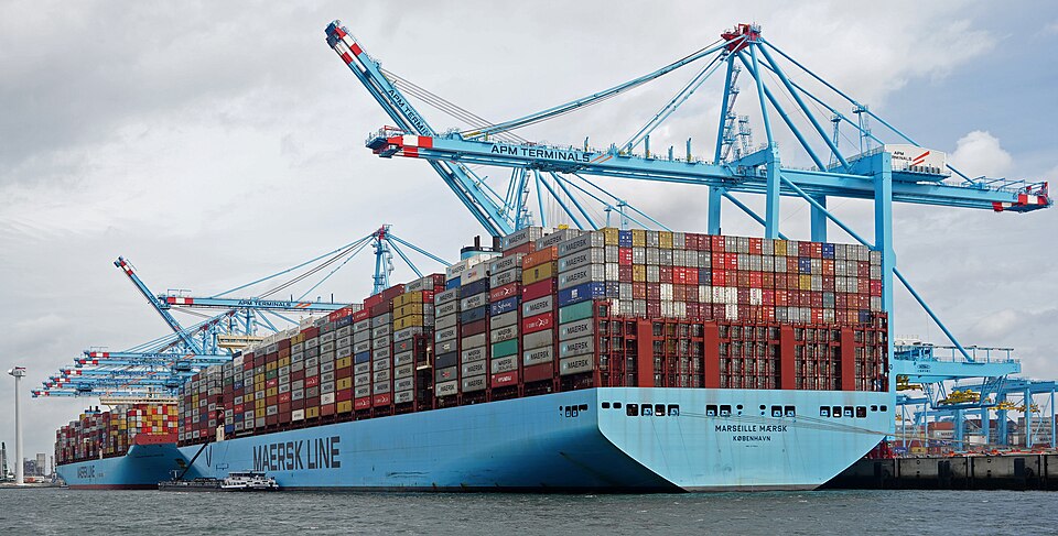 A modern ultra-large container ship stacked with thousands of containers.
