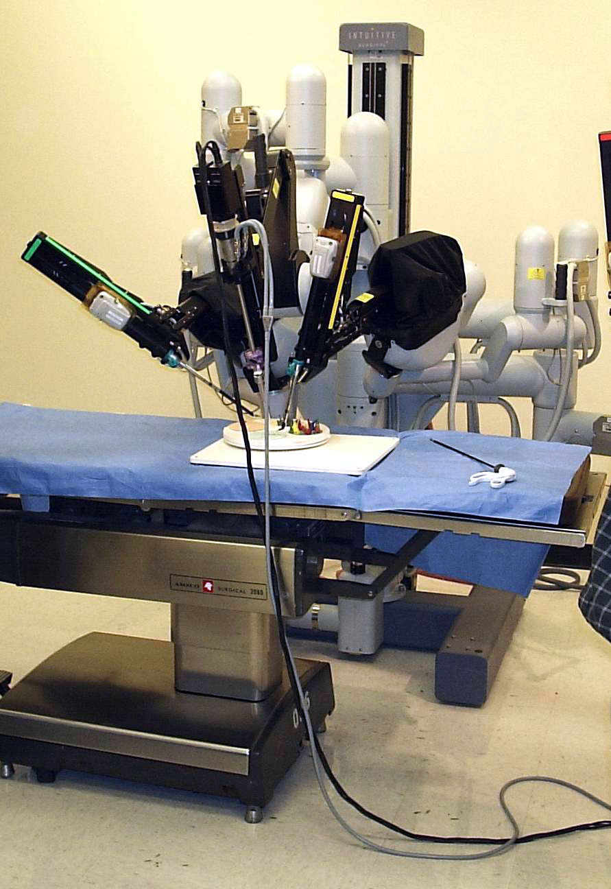 A da Vinci robotic surgical system console and patient-side manipulator arms.