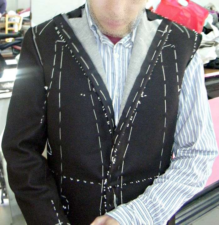 A bespoke tailor's workshop with patterns, shears and a partly made jacket.